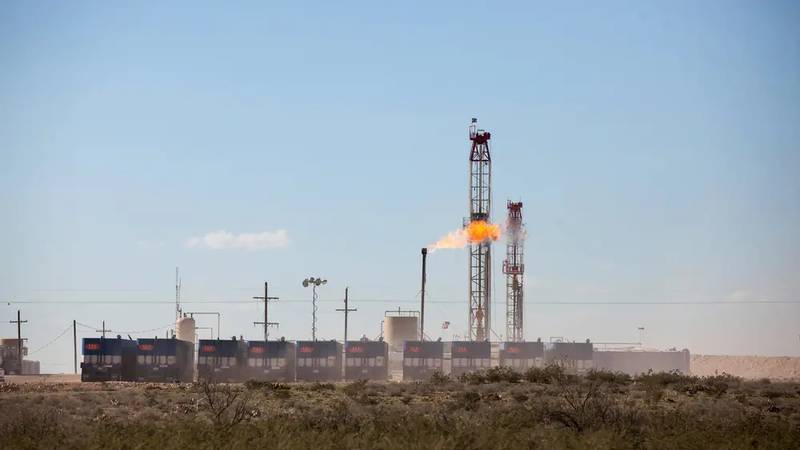 A flame burning natural gas is seen on an oil rig outside of Mentone. A new law will stop...