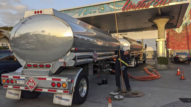 In this May 20, 2021 photo, a fuel truck driver checks the gasoline tank level at a United Oil...